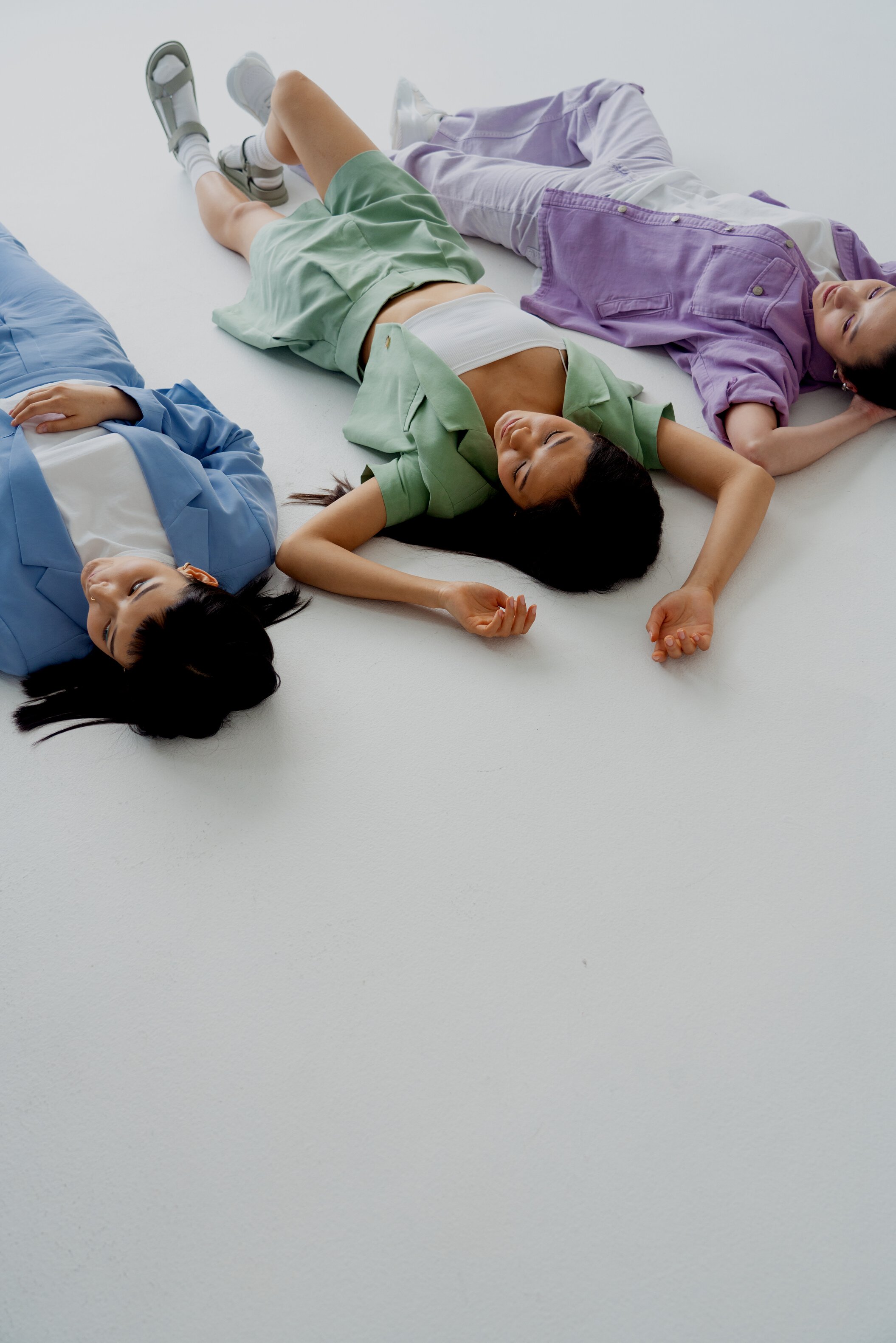 Fashionable Women Lying on White Floor